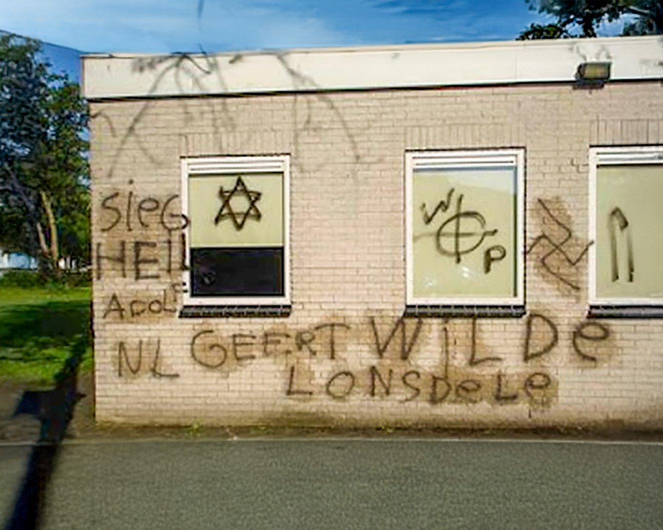 en gebouw in Veendam met nazi-symbolen en haatdragende leuzen zoals “Sieg Heil”, een swastika, en de naam Geert Wilders, aangebracht met zwarte graffiti.