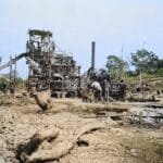 Historisch beeld van industriële activiteiten in Congo met arbeiders en koloniale infrastructuur.