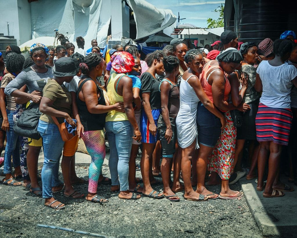 Inwoners van Port-au-Prince staan in de rij voor voedsel bij centrale keukens.