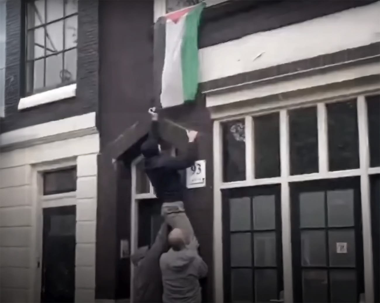 Israëlische fans verwijderen Palestijnse vlag in Amsterdam.