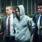 Martin Shkreli wordt gearresteerd en begeleid door twee agenten in zakelijke kleding.