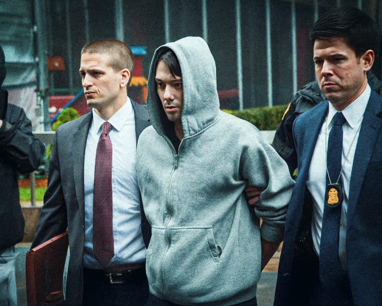 Martin Shkreli wordt gearresteerd en begeleid door twee agenten in zakelijke kleding.