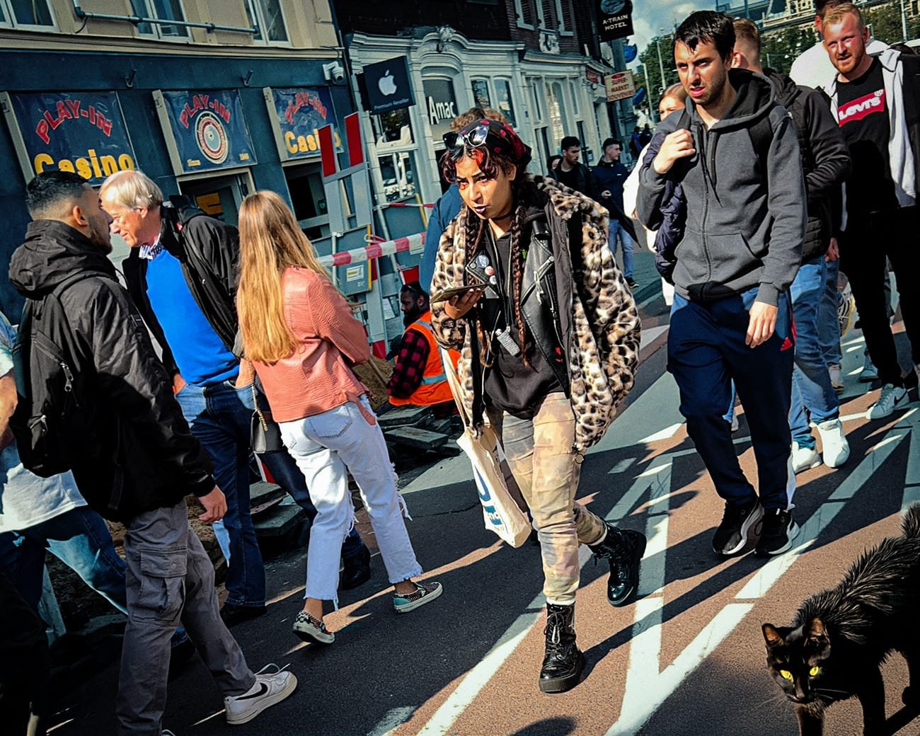 Straat in Amsterdam met drukte van toeristen en bewoners, symbool voor massatoerisme en overlast.