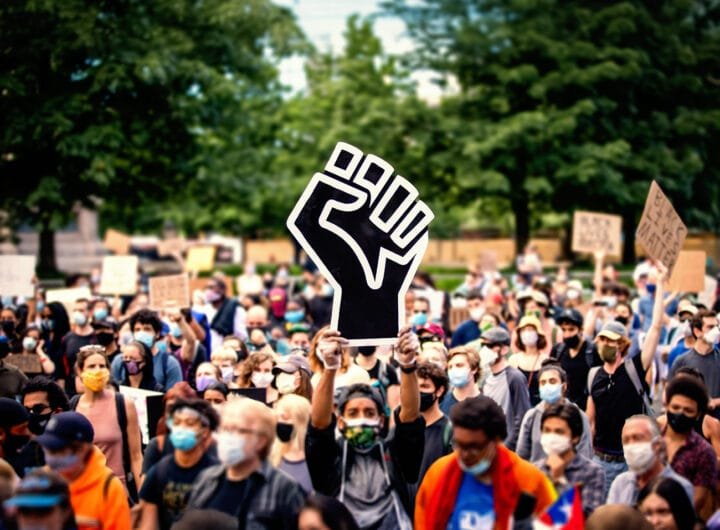 Demonstranten tijdens een Black Lives Matter-protest, met een gebalde vuist als symbool van solidariteit en verzet tegen raciale ongelijkheid.