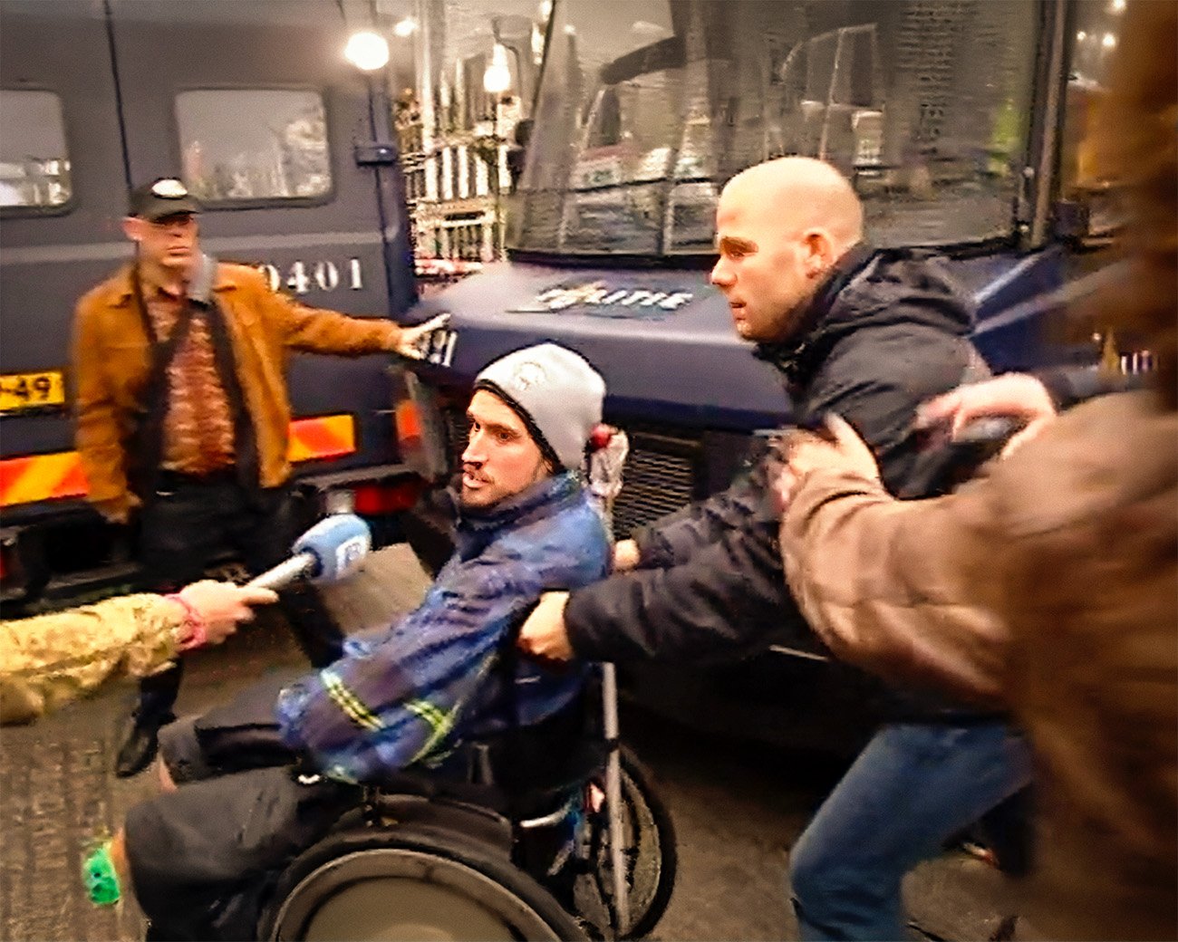 Demonstrant in rolstoel wordt door politieagent weggeduwd tijdens protest bij het Maagdenhuis.