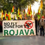 Protestmars met demonstranten die Rojava ondersteunen, met een groot spandoek met de tekst ‘No Fly Zone for Rojava’.