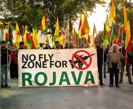 Protestmars met demonstranten die Rojava ondersteunen, met een groot spandoek met de tekst ‘No Fly Zone for Rojava’.