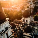 Luchtfoto van een beschadigde kerk in Odessa bij zonsondergang, omringd door historische gebouwen en groen.