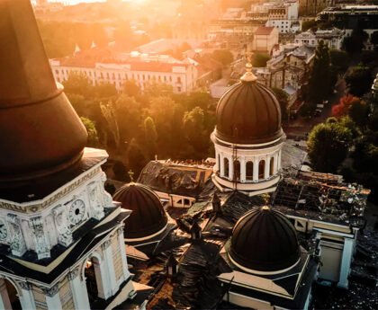 Luchtfoto van een beschadigde kerk in Odessa bij zonsondergang, omringd door historische gebouwen en groen.