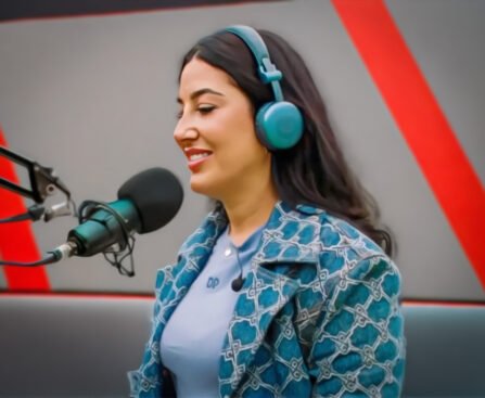 Mahi Khalesi met koptelefoon tijdens een radio-interview in een studio.