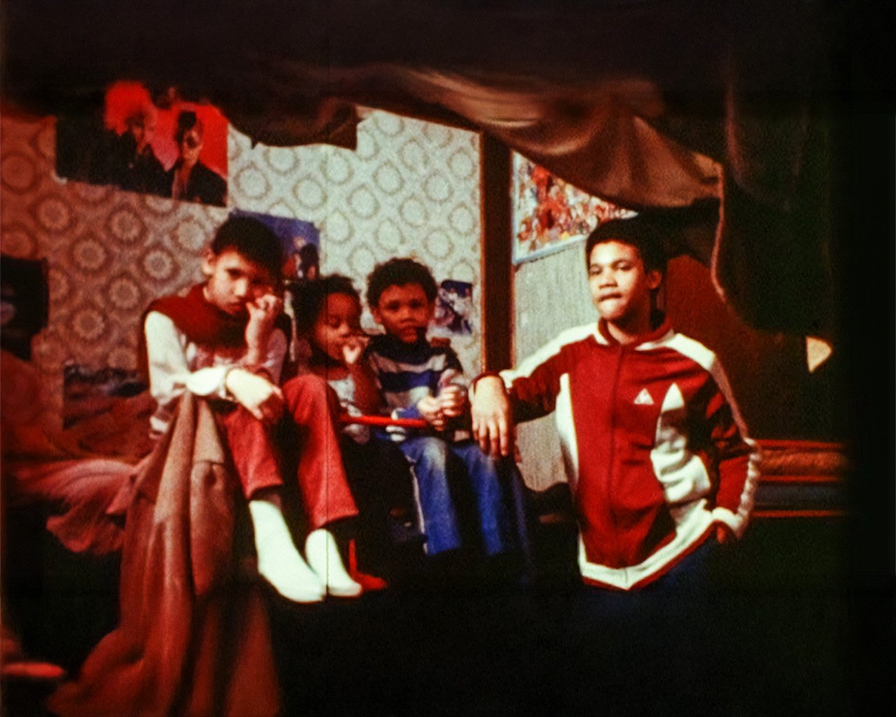 Kinderen in een overvolle kamer in Amsterdam, vastgelegd in de documentaire Onderneming Onderdak (1982) over migrantenhuisvesting en uitbuiting.