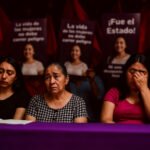 Vrouwen rouwen tijdens protest met foto’s van vermoorde mensenrechtenactivist Sandra Domínguez en spandoeken met teksten tegen feminicide in Mexico.