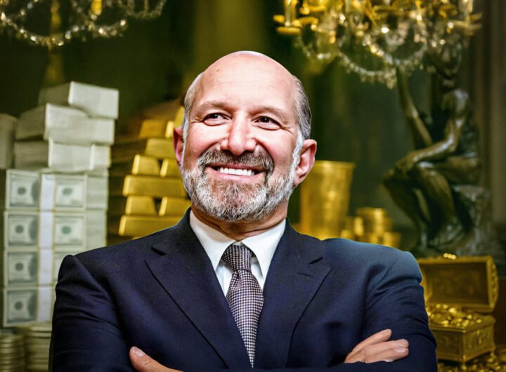 Howard Lutnik glimlacht zelfverzekerd voor een achtergrond vol geld en goudstaven
