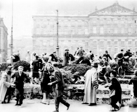 Mensen vluchten voor kogels op de Dam in Amsterdam tijdens schietpartij op 7 mei 1945