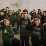 Kinderen op een schoolplein brengen groet, met speelse maar serieuze gezichtsuitdrukking, verwijzend naar collectieve rituelen van herinnering.