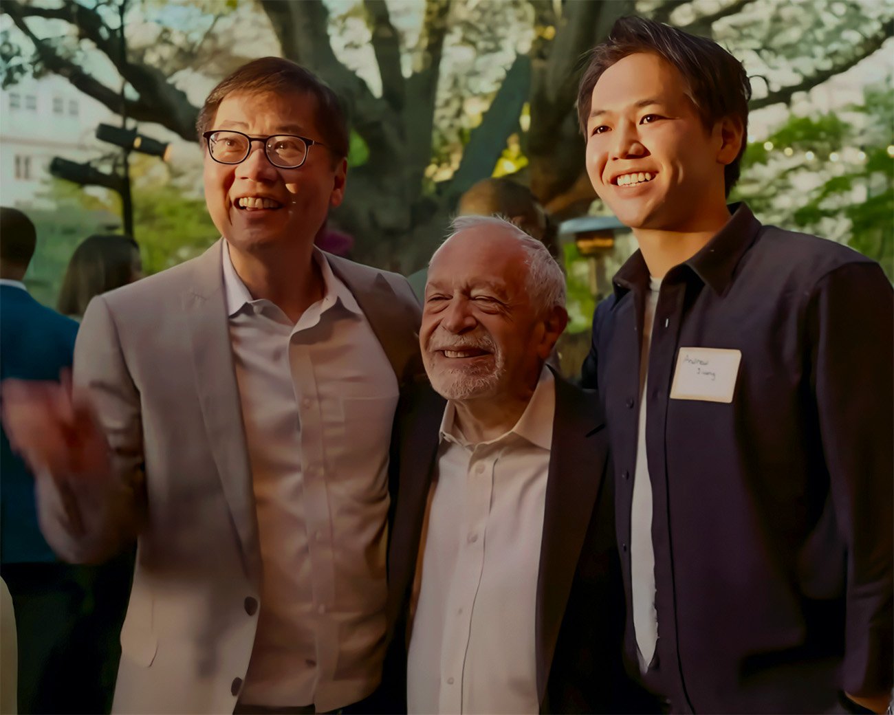 Robert Reich poseert met twee aanwezigen tijdens een bijeenkomst in de buitenlucht
