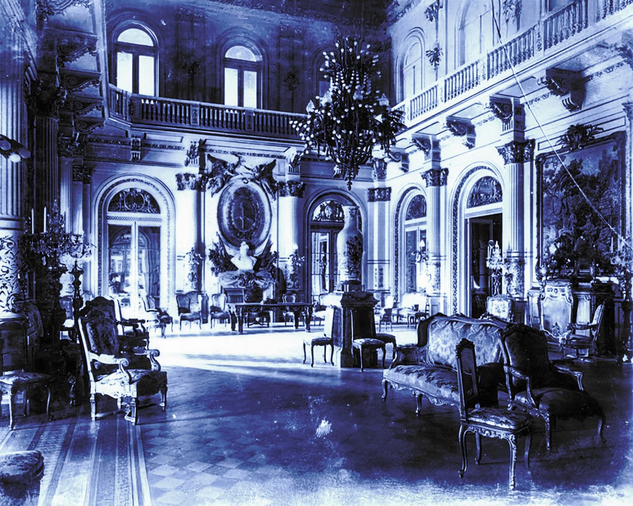 Luxe interieur van een Argentijns paleis met marmeren vloeren, hoge plafonds en rijk versierde meubels, symbool voor de rijkdom van een kleine elite.
