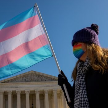 Persoon met transgendervlag voor het Amerikaanse Hooggerechtshof