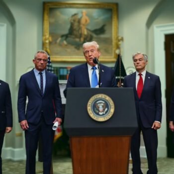 Donald Trump spreekt tijdens persconferentie over paracetamol en autisme, geflankeerd door figuren zonder medisch-wetenschappelijke achtergrond