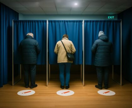 Drie mensen stemmen in een stemhokje tijdens de Nederlandse verkiezingen van 2025