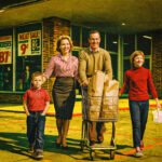 Amerikaans gezin in jaren 50 bij supermarkt met volgeladen winkelwagentje