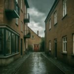 Natte, verlaten Amsterdamse steeg met donkere wolken en twee fietsen tegen bakstenen gevels.