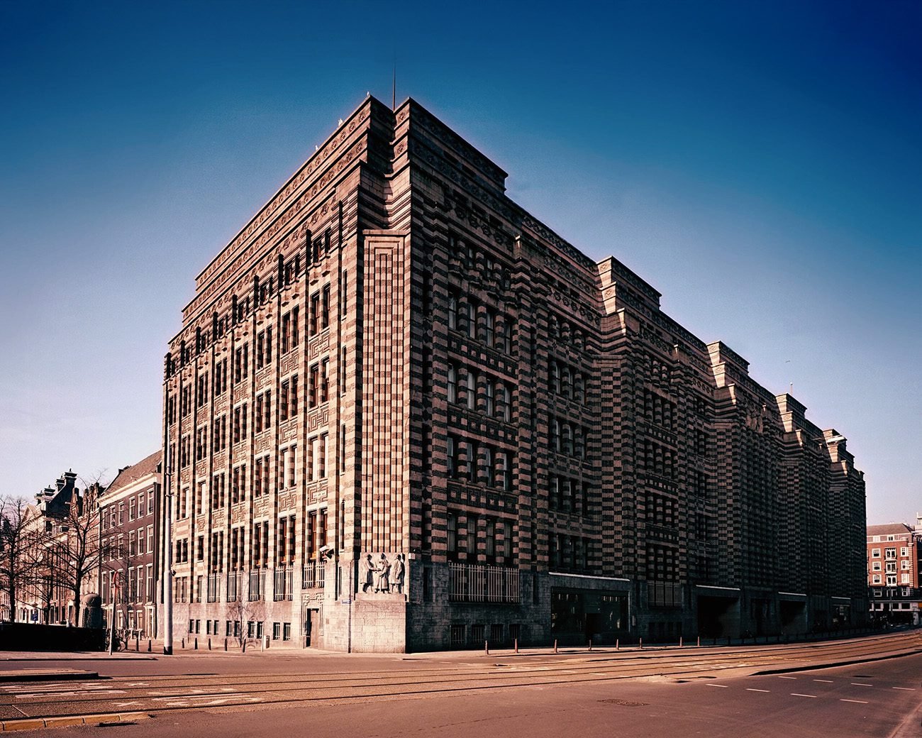 Voormalig hoofdkantoor van de Nederlandsche Handel-Maatschappij in Amsterdam, gebouwd op koloniale handelswinst en omgeven door beelden van gouverneurs-generaal.