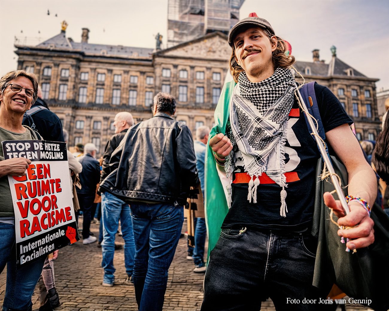 Demonstranten op de Dam met antiracisme-borden en een persoon die een Palestijnse sjaal draagt, tijdens een protest tegen haat en uitsluiting.