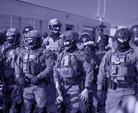 Groep zwaarbewapende federale agenten staat opgesteld tijdens een grootschalige operatie in een stedelijke omgeving.