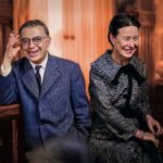 Simone de Beauvoir en Jean-Paul Sartre zittend naast elkaar in Parijs, lachend, als partners in leven en denken.