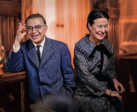 Simone de Beauvoir en Jean-Paul Sartre zittend naast elkaar in Parijs, lachend, als partners in leven en denken.