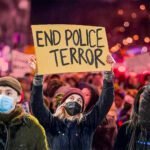 Demonstranten houden borden vast met een oproep tegen politiegeweld en de namen van slachtoffers tijdens een protest in de Verenigde Staten.