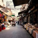 Marktstraat in Qamişlo met zakken granen, winkels en mensen die zich door de straat bewegen