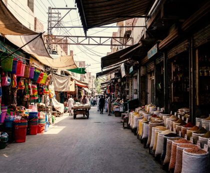 Marktstraat in Qamişlo met zakken granen, winkels en mensen die zich door de straat bewegen