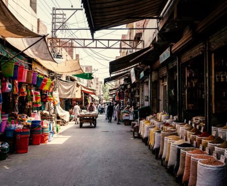 Marktstraat in Qamişlo met zakken granen, winkels en mensen die zich door de straat bewegen