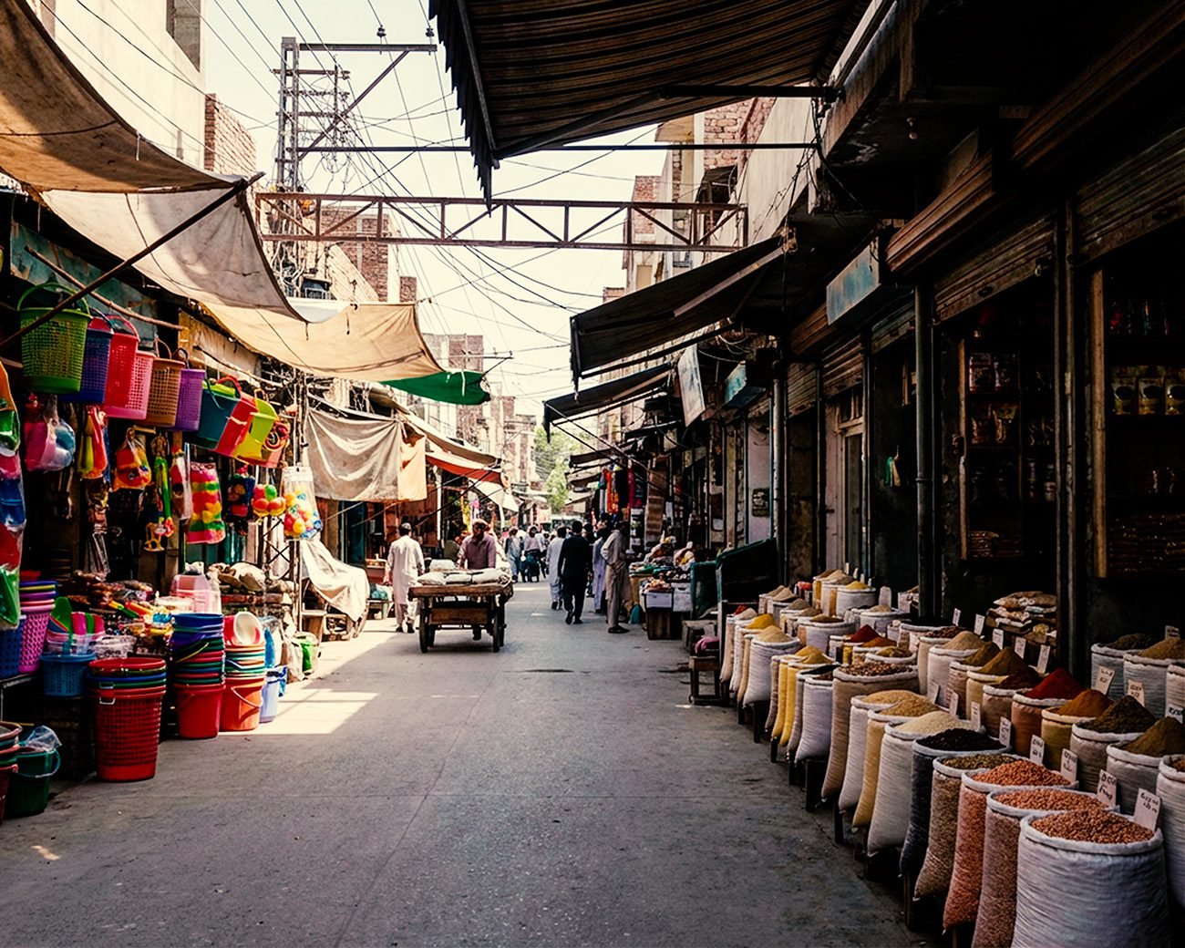Marktstraat in Qamişlo met zakken granen, winkels en mensen die zich door de straat bewegen
