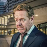 Politicus bij regeringsgebouw tijdens debat over buitenlands optreden en internationale rechtvaardiging