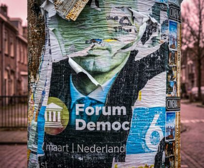 Verweerde verkiezingsposter van Forum voor Democratie op straatpaal in Nederlandse woonwijk