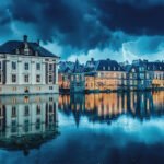 Het Binnenhof in Den Haag bij schemering met verlichte ramen en reflectie in het water