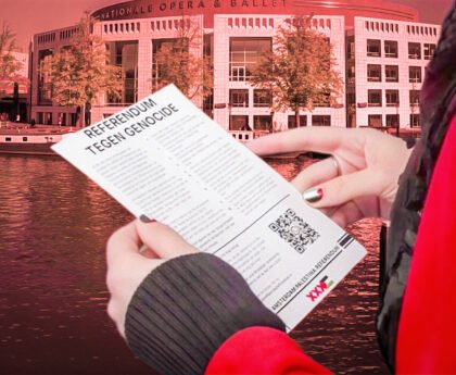 Persoon houdt flyer van Amsterdam Palestina Referendum vast voor de Stopera in Amsterdam