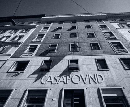Gevel van het CasaPound-hoofdkwartier in Rome, met de naam CasaPound boven de ingang en een vlag aan de gevel.