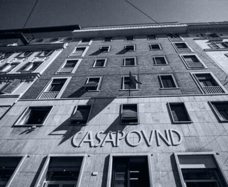 Gevel van het CasaPound-hoofdkwartier in Rome, met de naam CasaPound boven de ingang en een vlag aan de gevel.