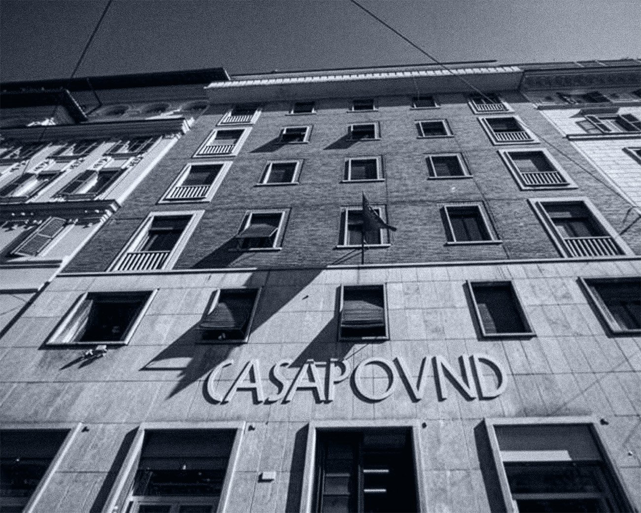 Gevel van het CasaPound-hoofdkwartier in Rome, met de naam CasaPound boven de ingang en een vlag aan de gevel.