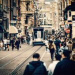 Drukke Leidsestraat in Amsterdam met voetgangers en een tram, als beeld van dagelijkse haast en stedelijke druk.