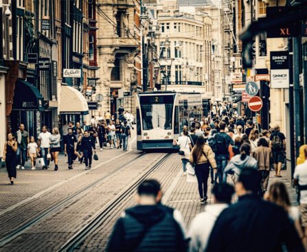 Drukke Leidsestraat in Amsterdam met voetgangers en een tram, als beeld van dagelijkse haast en stedelijke druk.