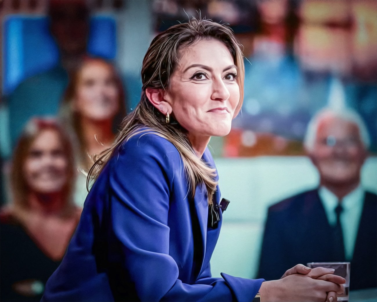 Politicus aan een talkshowtafel met publiek op de achtergrond, tijdens een gesprek over persoonlijke verhalen en politieke macht.