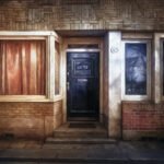 Voordeur van een woning met gesloten gordijnen, als beeld bij huishoudelijke zorg die onder druk staat.