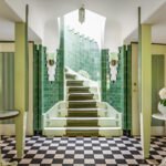 Hal van het Meerlhuis in Park Meerwijk in Bergen, ontworpen door Margaret Kropholler, met groene tegels, trap en zwart-witte vloer.