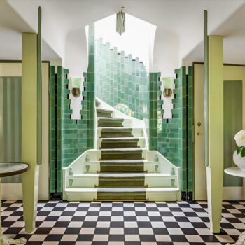 Hal van het Meerlhuis in Park Meerwijk in Bergen, ontworpen door Margaret Kropholler, met groene tegels, trap en zwart-witte vloer.