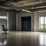 Lege kantoorruimte met één bureaustoel, een raam naar buiten en leidingen aan het plafond, als beeld bij bore-out en leeg werk.